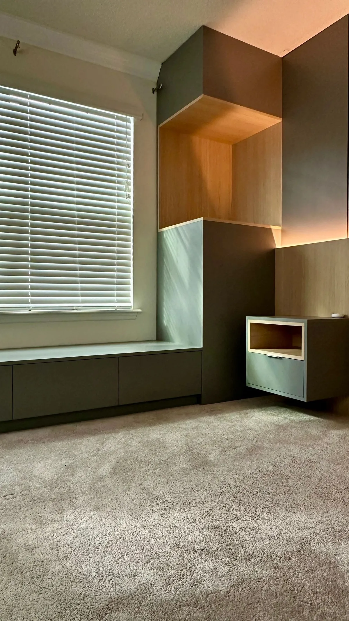 Detail of the oak and gray window seat with drawers and a floating nightstand with LED backlighting