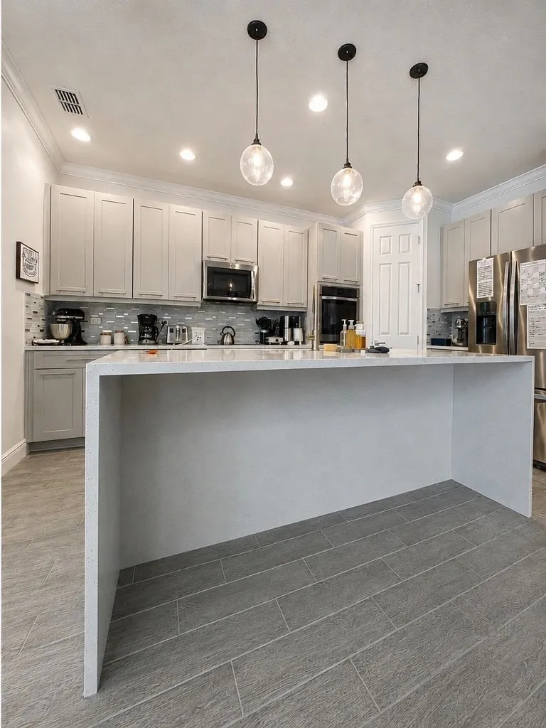 After: Dark kitchen refinished light, with a waterfall island
