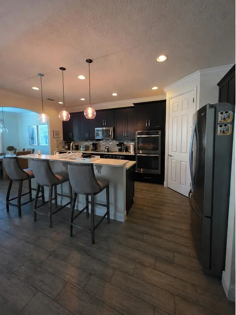 Before: Dark kitchen refinished light, with a waterfall island